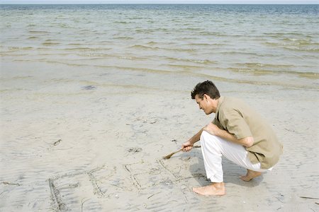 Barefoot man writing word "free" on beach with stick, full length Foto de stock - Sin royalties Premium, Código: 695-03377558