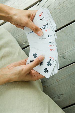 paciência - Woman holding deck of cards splayed in hands, cropped view Foto de stock - Royalty Free Premium, Número: 695-03377650