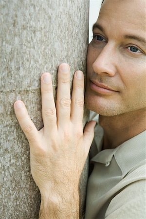 simsearch:696-03401960,k - Man hugging tree trunk, looking away, close-up Stock Photo - Premium Royalty-Free, Code: 695-03377740