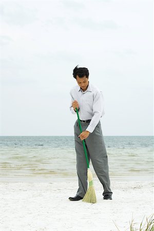 disheveled man full body one person photo - Man standing on beach sweeping with broom, full length Stock Photo - Premium Royalty-Free, Code: 695-03377757