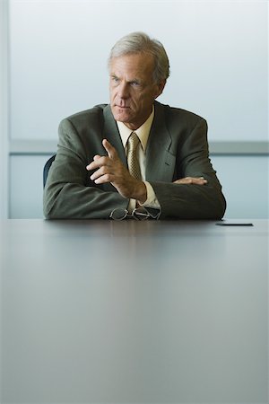 rebuking - Businessman seated, furrowing brow and pointing finger Stock Photo - Premium Royalty-Free, Code: 695-03377830