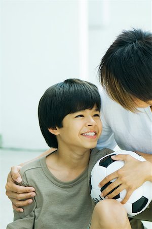 simsearch:632-01380362,k - Boy holding soccer ball, smiling at father, portrait Foto de stock - Royalty Free Premium, Número: 695-03377854