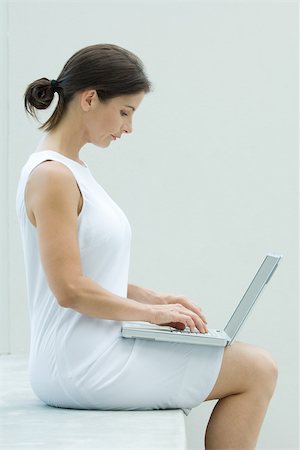 simsearch:649-07279534,k - Woman sitting, using laptop computer, side view Foto de stock - Sin royalties Premium, Código: 695-03377906
