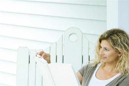 simsearch:695-03377942,k - Woman sitting on bench, reading book, cropped view Stock Photo - Premium Royalty-Free, Code: 695-03377941