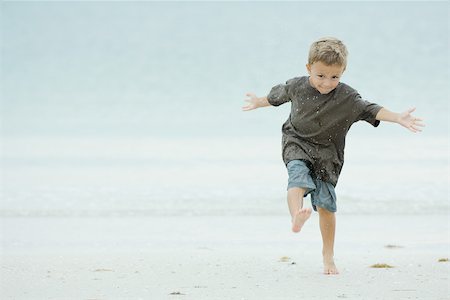 simsearch:695-03378542,k - Young boy kicking sand at the beach, full length Foto de stock - Sin royalties Premium, Código: 695-03377966