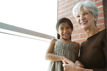 simsearch:695-03377503,k - Grandmother and granddaughter holding hands, both smiling, low angle view Stock Photo - Premium Royalty-Free, Code: 695-03377997