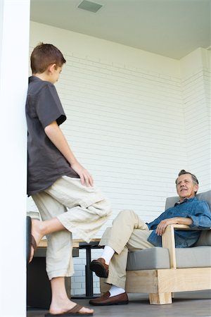 Grandfather and grandson face to face on porch, man sitting, boy standing Stock Photo - Premium Royalty-Free, Code: 695-03378003