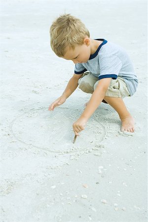 drawing on the sand with a stick - Little boy crouching at the beach, drawing in sand with stick Stock Photo - Premium Royalty-Free, Code: 695-03378091