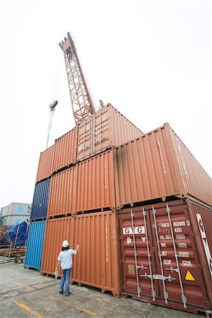 simsearch:649-03666507,k - Woman standing in front of stacked industrial storage units, rear view Stock Photo - Premium Royalty-Free, Code: 695-03378129