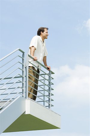 simsearch:632-01828538,k - Man leaning against railing, looking into distance, low angle view Stock Photo - Premium Royalty-Free, Code: 695-03378170