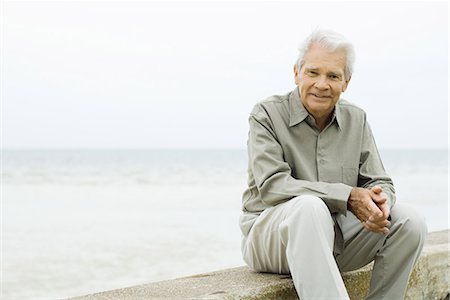 retired content - Senior man sitting near sea, smiling at camera Stock Photo - Premium Royalty-Free, Code: 695-03378208