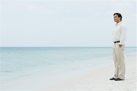simsearch:696-03395430,k - Man standing on beach, looking at view Foto de stock - Royalty Free Premium, Número: 695-03378223