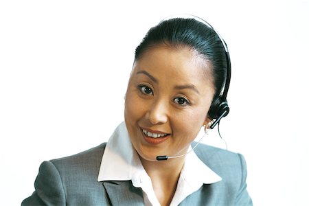 Businesswoman wearing headset, smiling at camera, close-up Stock Photo - Premium Royalty-Free, Code: 695-03378351