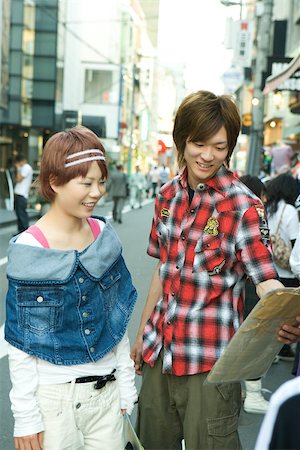 Young couple standing on city street, looking at package together Stock Photo - Premium Royalty-Free, Code: 695-03378401