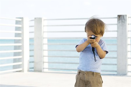 simsearch:400-06130548,k - Toddler boy standing outdoors, hiding behind flashlight, peeking at camera Foto de stock - Sin royalties Premium, Código: 695-03378550