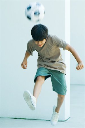 simsearch:695-03377206,k - Little boy playing with soccer ball, jumping, head down Stock Photo - Premium Royalty-Free, Code: 695-03378632