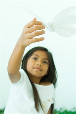 phoney smile - Little girl touching butterfly, low angle view Stock Photo - Premium Royalty-Free, Code: 695-03378656