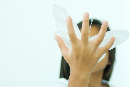 Little girl holding butterfly, hand in front of face, low angle view Stock Photo - Premium Royalty-Free, Code: 695-03378657