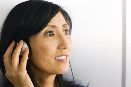 simsearch:695-03379834,k - Femme à l'écoute au casque, remettre les oreilles, souriant, à la recherche de suite Photographie de stock - Premium Libres de Droits, Code: 695-03378668