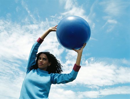 simsearch:632-01828538,k - Female holding ball outdoors, arms raised, low angle view Stock Photo - Premium Royalty-Free, Code: 695-03378728