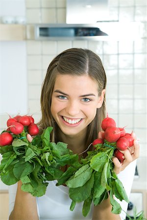 simsearch:695-03378760,k - Young woman holding bunches of radishes in hands, smiling at camera, portrait Foto de stock - Sin royalties Premium, Código: 695-03378747