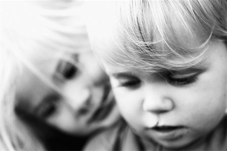 Girl leaning her head on younger brother's shoulder, both looking down, portrait, close-up Stock Photo - Premium Royalty-Free, Code: 695-03378740