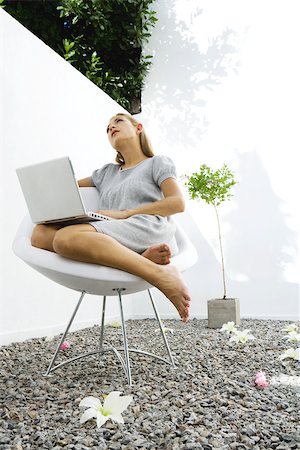 simsearch:632-02645076,k - Woman sitting outdoors using laptop Fotografie stock - Premium Royalty-Free, Codice: 695-03378890