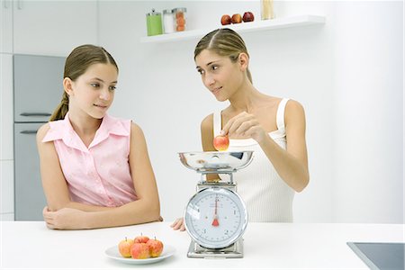 simsearch:695-03378760,k - Woman and girl in kitchen, weighing apple Foto de stock - Sin royalties Premium, Código: 695-03378905