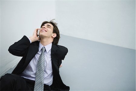 simsearch:632-02745019,k - Young man in suit sitting on the ground, using cell phone, head back Stock Photo - Premium Royalty-Free, Code: 695-03378933