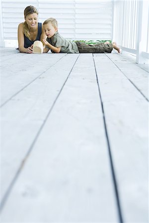 peace of mind people - Mother and son lying on deck, looking at wooden object, low angle view Stock Photo - Premium Royalty-Free, Code: 695-03379014