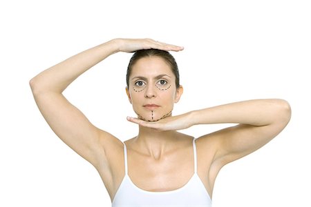 simsearch:695-03379049,k - Femme avec des marques de chirurgie plastique sur le visage, cadrage tête avec les mains, en regardant la caméra Photographie de stock - Premium Libres de Droits, Code: 695-03379024