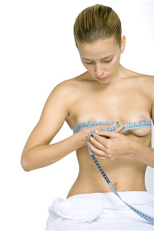 Nude woman measuring breasts with measuring tape, looking down Foto de stock - Sin royalties Premium, Código: 695-03379046