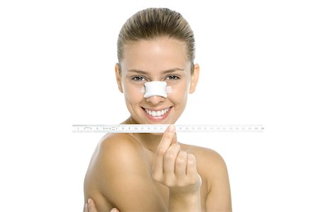 simsearch:695-03379046,k - Woman with bandaged nose, holding measuring tape, smiling at camera Stock Photo - Premium Royalty-Free, Code: 695-03379047