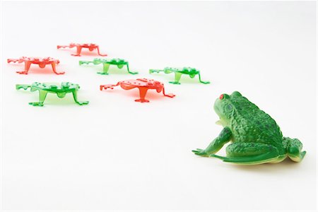 frog - Plastic frog facing group of frog shaped game pieces Foto de stock - Sin royalties Premium, Código: 695-03379059