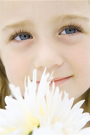 simsearch:632-03193343,k - Little girl with flowers, looking up, smiling, portrait Foto de stock - Royalty Free Premium, Número: 695-03379075