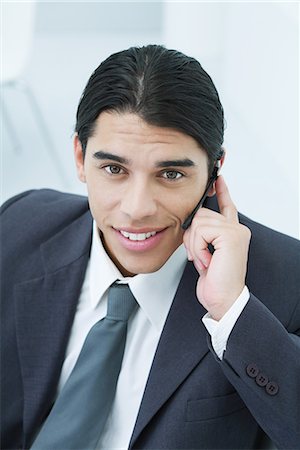 simsearch:633-01837165,k - Young businessman using cell phone, smiling at camera, portrait Fotografie stock - Premium Royalty-Free, Codice: 695-03379096