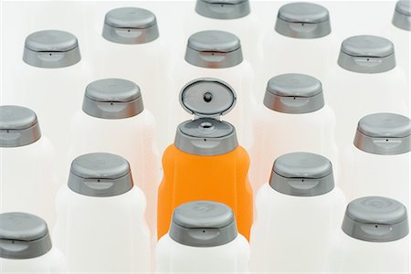 Open orange bottle among group of  closed white bottles Stock Photo - Premium Royalty-Free, Code: 695-03379130