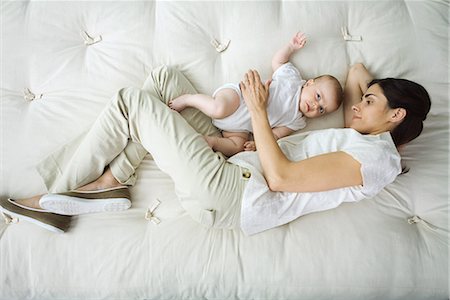 directly above lying woman full length - Mother and infant lying together on bed, high angle view Stock Photo - Premium Royalty-Free, Code: 695-03379148