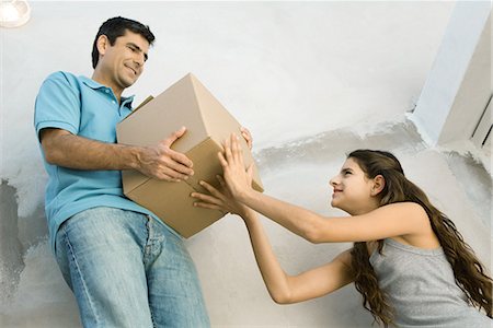 Father and daughter moving cardboard box together, low angle view Stock Photo - Premium Royalty-Free, Code: 695-03379143