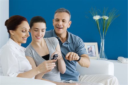 simsearch:695-03379156,k - Mature parents and teen daughter looking at cell phone together, smiling Stock Photo - Premium Royalty-Free, Code: 695-03379154
