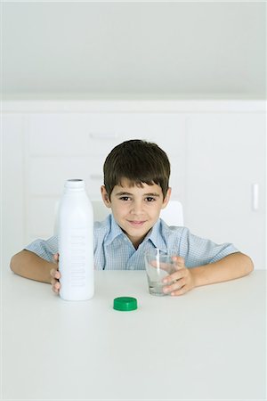 simsearch:695-05768828,k - Little boy holding bottle of milk and empty glass, smiling at camera Fotografie stock - Premium Royalty-Free, Codice: 695-03379173