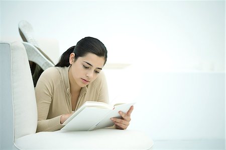 simsearch:632-03027019,k - Young woman lying on couch, reading book Stock Photo - Premium Royalty-Free, Code: 695-03379194