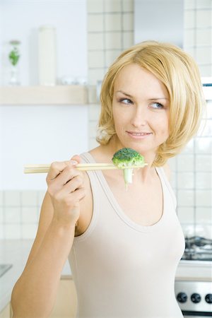 simsearch:695-03378760,k - Blonde woman holding piece of broccoli with chopsticks Foto de stock - Sin royalties Premium, Código: 695-03379289