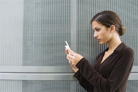 simsearch:695-03378072,k - Well-dressed young female holding up cell phone, side view Stock Photo - Premium Royalty-Free, Code: 695-03379317