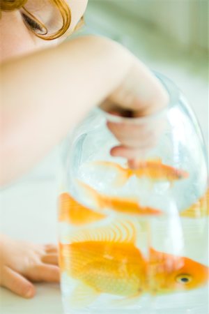 simsearch:632-03193343,k - Girl reaching into goldfish bowl, cropped Foto de stock - Royalty Free Premium, Número: 695-03379323