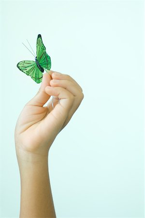 simsearch:695-03378657,k - Child's hand holding fake butterfly Foto de stock - Sin royalties Premium, Código: 695-03379345