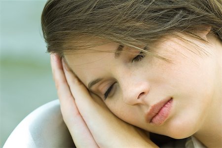 Teenage girl resting head on hands, close-up Stock Photo - Premium Royalty-Free, Code: 695-03379358