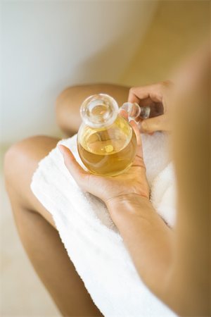 simsearch:695-03379369,k - Woman wrapped in towel, holding jar of massage oil, cropped Stock Photo - Premium Royalty-Free, Code: 695-03379369