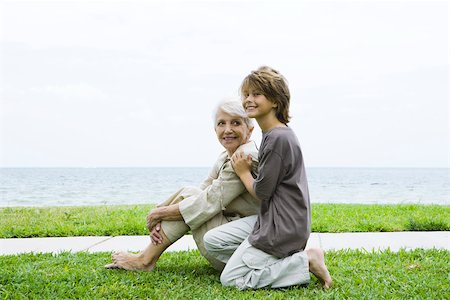 simsearch:696-03395223,k - Grandmother and grandson sitting outdoors together, smiling, sea in background Foto de stock - Sin royalties Premium, Código: 695-03379459