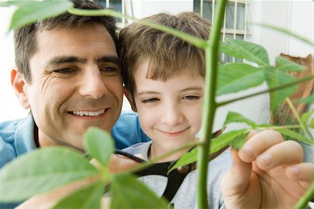 family yard work - Father and son pruning plant together, smiling Stock Photo - Premium Royalty-Free, Code: 695-03379467